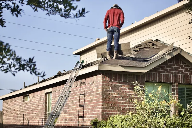Professional roofer working on a residential roof in Raisin